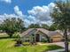 Charming single-story home with lush landscaping, brick walkway, and two-car garage at 1902 Southern Dunes Blvd, Haines City, FL 33844