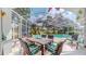 Screened-in patio featuring a pool, dining set, and seating area, perfect for relaxation and entertaining by the water at 1902 Southern Dunes Blvd, Haines City, FL 33844