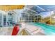 Inviting pool area set within a screened enclosure, complemented by comfortable outdoor seating and lush landscaping at 1902 Southern Dunes Blvd, Haines City, FL 33844