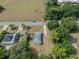 Drone shot exhibiting the home's location along a quiet road, neighbored by mature trees at 1949 Old Bartow Rd, Lake Wales, FL 33859
