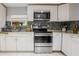Close-up showcasing stainless steel appliances, granite countertops, and tiled backsplash in a modern kitchen at 1949 Old Bartow Rd, Lake Wales, FL 33859