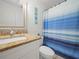 Bathroom featuring toilet, vanity with tan countertop, nautical decor, mirror, and shower at 2100 Magnolia Ave, Haines City, FL 33844