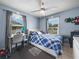 Cozy bedroom with desk, ceiling fan, window, gray curtains and blue plaid comforter at 2100 Magnolia Ave, Haines City, FL 33844