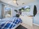 Blue bedroom featuring TV, ceiling fan, closet, window with gray curtains and plaid comforter at 2100 Magnolia Ave, Haines City, FL 33844