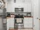 Bright kitchen featuring stainless steel appliances, tan countertops, and white cabinets at 2100 Magnolia Ave, Haines City, FL 33844