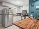 Bright kitchen featuring stainless steel appliances, white cabinets, butcher block island, and modern countertops at 2100 Magnolia Ave, Haines City, FL 33844