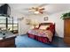 Bright bedroom with ceiling fan and sliding doors to enclosed porch at 2180 San Marcos Se Cir # 401, Winter Haven, FL 33880