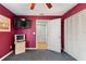 Red bedroom features large storage closet and flat screen TV at 2180 San Marcos Se Cir # 401, Winter Haven, FL 33880