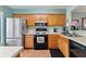 Kitchen with wood cabinets, tile flooring, and stainless steel appliances at 2180 San Marcos Se Cir # 401, Winter Haven, FL 33880