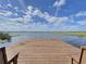 Tranquil lake view from a wooden dock, perfect for relaxation and water activities at 2180 San Marcos Se Cir # 401, Winter Haven, FL 33880