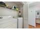 Bright laundry room with modern white washer and dryer and convenient shelving at 2180 San Marcos Se Cir # 401, Winter Haven, FL 33880