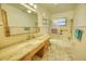 This bathroom features a granite countertop, a large mirror, and a shower-tub combo with glass doors at 230 W Harbord St, Lake Alfred, FL 33850