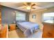This bedroom features a ceiling fan, a large bed, and two windows that provide natural light at 230 W Harbord St, Lake Alfred, FL 33850