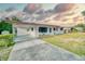 Charming single-story home featuring a covered carport and a well-maintained front lawn at 230 W Harbord St, Lake Alfred, FL 33850