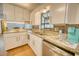 Well-lit kitchen featuring granite countertops, white cabinets, and stainless steel appliances at 230 W Harbord St, Lake Alfred, FL 33850