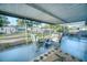 This screened-in porch features wicker furniture, a ceiling, and a view of the backyard at 230 W Harbord St, Lake Alfred, FL 33850