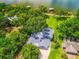 Aerial view of a beautiful home surrounded by lush greenery and a lake at 250 Brigham Nw Rd, Winter Haven, FL 33881