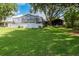 Lush backyard featuring a spacious screened-in patio and mature shade trees at 250 Brigham Nw Rd, Winter Haven, FL 33881