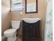 A cozy bathroom with a dark wood vanity, matching framed mirror, and a standard toilet at 250 Brigham Nw Rd, Winter Haven, FL 33881