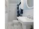 Bathroom with white pedestal sink, walk-in shower, and black and white mosaic tile floor at 250 Brigham Nw Rd, Winter Haven, FL 33881