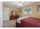 This bedroom offers a ceiling fan, neutral walls, carpet, a window and a dresser at 250 Brigham Nw Rd, Winter Haven, FL 33881