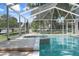Sparkling screened-in pool and spa with expansive views of the surrounding lush greenery and blue skies at 250 Brigham Nw Rd, Winter Haven, FL 33881