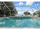 Enjoy the swimming pool area with a spa, screened enclosure, and scenic lake views at 250 Brigham Nw Rd, Winter Haven, FL 33881