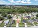 An aerial view showing the neighborhood and many single Gathering homes bordering a heavily wooded area and lake at 251 Kings Pond Ave, Winter Haven, FL 33880