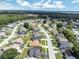 Overhead view of the homes in the neighborhood with their manicured lawns, trees and pond at 251 Kings Pond Ave, Winter Haven, FL 33880