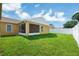 A spacious backyard with a green lawn, a storage shed and enclosed patio at 251 Kings Pond Ave, Winter Haven, FL 33880