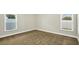 Bright bedroom features neutral paint, carpet, and natural light from two windows at 251 Kings Pond Ave, Winter Haven, FL 33880