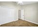 Bedroom with a carpeted floor, ceiling fan, neutral paint, and double door closet at 251 Kings Pond Ave, Winter Haven, FL 33880