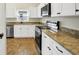 Modern kitchen featuring stainless steel appliances, granite countertops, and white cabinetry at 251 Kings Pond Ave, Winter Haven, FL 33880