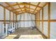 Spacious storage shed with wooden beams, shelving and a plywood floor offers ample room for tools and equipment at 251 Kings Pond Ave, Winter Haven, FL 33880