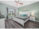 Bedroom with large window, ceiling fan, and wood floors at 2824 Attwater Loop, Winter Haven, FL 33884