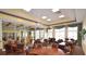 Well-lit clubhouse room with tables, chairs, and large windows overlooking the garden at 2824 Attwater Loop, Winter Haven, FL 33884