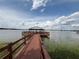 Scenic wooden pier extending over the water with a covered gazebo at the end at 2824 Attwater Loop, Winter Haven, FL 33884