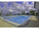 Outdoor pool with lounge chairs and beautiful water views under a cloudy blue sky at 2824 Attwater Loop, Winter Haven, FL 33884
