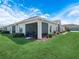 Exterior view of home showing a screened in lanai, manicured lawn, and landscaping at 2824 Attwater Loop, Winter Haven, FL 33884