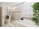 Bright bathroom features a tub and shower with modern tilework, offering a clean and relaxing space at 2980 Dayton Dr, Winter Haven, FL 33884