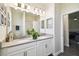 Bathroom featuring double sinks with white cabinets, gray countertop, and views into the home at 2980 Dayton Dr, Winter Haven, FL 33884