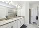 Elegant bathroom featuring double sinks, white cabinetry, and walk-in shower for a luxurious experience at 2980 Dayton Dr, Winter Haven, FL 33884