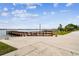 Picturesque lakeside view showcasing a long wooden dock extending into calm waters under a blue sky at 2980 Dayton Dr, Winter Haven, FL 33884