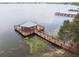 Stunning lake view featuring a wooden dock with a gazebo and walkway in a serene setting at 2980 Dayton Dr, Winter Haven, FL 33884