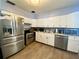 Bright kitchen features stainless steel appliances, white cabinetry, and light-colored wood-look flooring at 3022 Hickory Nw St, Winter Haven, FL 33881
