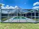 The screened in pool is surrounded by lush greenery and offers a refreshing escape at 3022 Hickory Nw St, Winter Haven, FL 33881