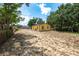 View of a yellow house with a large, fenced backyard and lots of trees at 305 Armour Ave, Auburndale, FL 33823