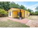 Charming yellow home featuring a cozy front porch and well-maintained landscaping at 305 Armour Ave, Auburndale, FL 33823
