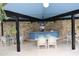 Outdoor grilling area with a stone wall, seating and lighting at 333 Lake Howard Nw Dr # 103C, Winter Haven, FL 33880