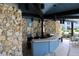 Outdoor cooking space with a stone wall and a counter with seating at 333 Lake Howard Nw Dr # 103C, Winter Haven, FL 33880